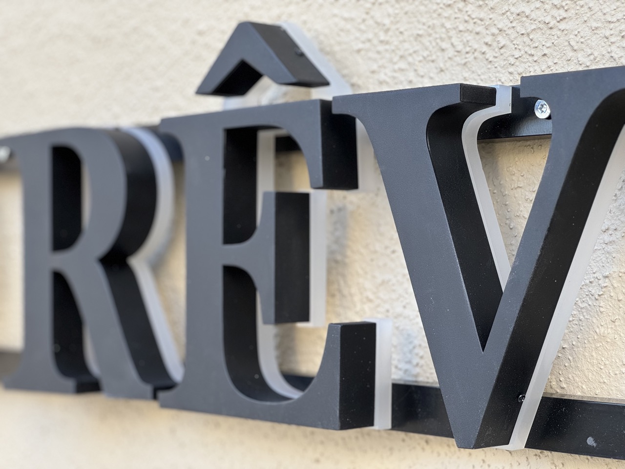 Modern butiksskylt i aluminium med företagets logotyp. Skylten är hållbar och stilren, och är installerad på en butik i Stockholm. Den kombinerar både estetik och funktionalitet för ett professionellt varumärkesintryck